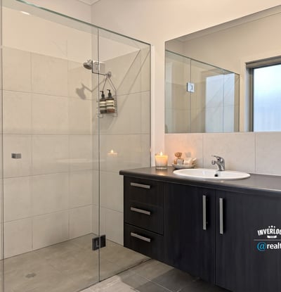 Modern bathroom featuring a spacious shower, sleek cabinetry, and natural light for a refreshing ambiance.