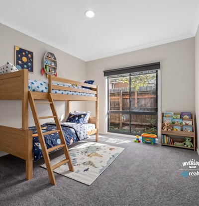 Bright, inviting kids' bedroom featuring a lofted bed and spacious play area with natural light.