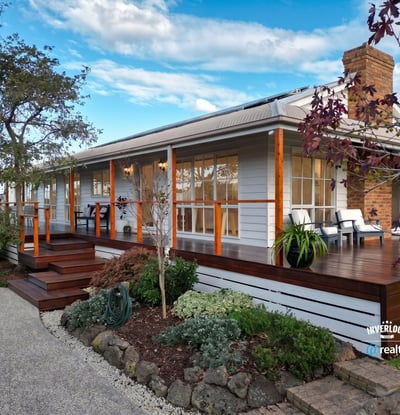 Inviting home features a spacious deck, landscaped garden, and picturesque setting, perfect for outdoor living.