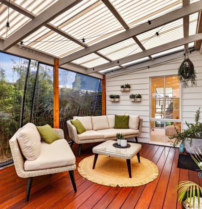 Inviting sunroom featuring comfortable seating, lush greenery, and abundant natural light for relaxed gatherings.