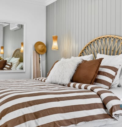 Cozy bedroom featuring a unique headboard, striped bedding, and modern accents for a relaxed atmosphere.
