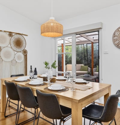 Bright dining area features a spacious table, inviting decor, and views of a cozy outdoor space.