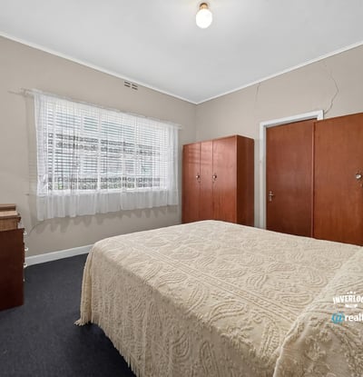 Bright and spacious bedroom featuring built-in wardrobes and ample natural light from large windows.