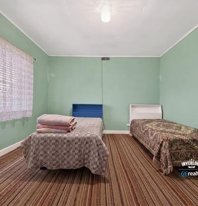 Bright and spacious bedroom with ample natural light, featuring two beds and distinctive patterned accents.