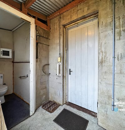 Functional entryway featuring a convenient bathroom and access to additional storage options.