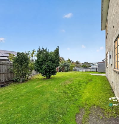 Spacious, grassy side yard offers potential for landscaping or outdoor activities, enhancing the property's appeal.