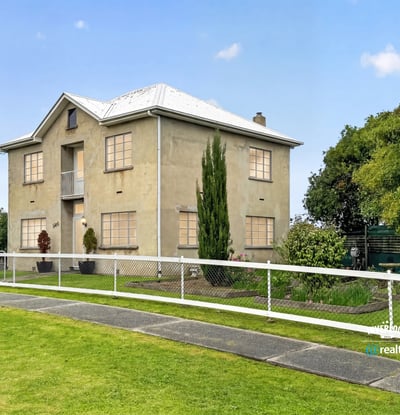 This spacious two-story home features large windows, a manicured lawn, and ample outdoor space for gatherings.