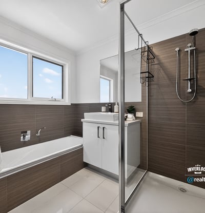 Modern bathroom featuring a glass shower, freestanding tub, and ample natural light from large windows.