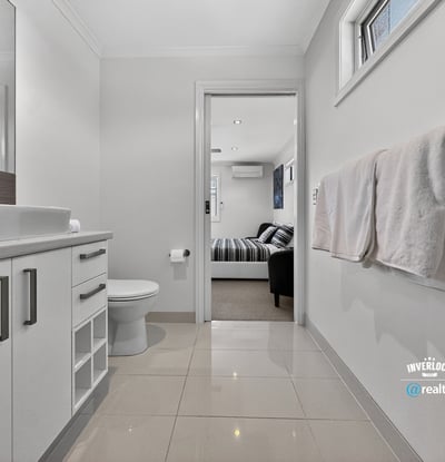 Modern bathroom featuring sleek cabinetry and contemporary finishes, seamlessly connecting to a cozy living area.