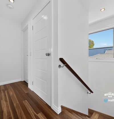 Bright and inviting hallway featuring warm wood flooring and ample natural light from the window.