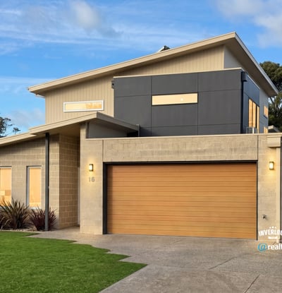 Contemporary home featuring unique architectural design, spacious garage, and vibrant landscaping in a desirable neighborhood.