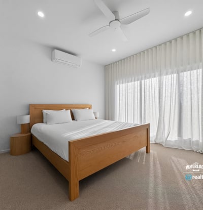 Bright and airy bedroom featuring large windows, modern furnishings, and ample natural light.