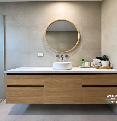 Discover a modern bathroom featuring sleek cabinetry, a striking round mirror, and contemporary fixtures.