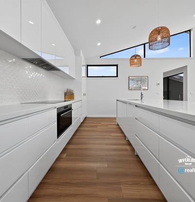 Bright and spacious kitchen featuring modern cabinetry, vast countertops, and stunning views through large windows.