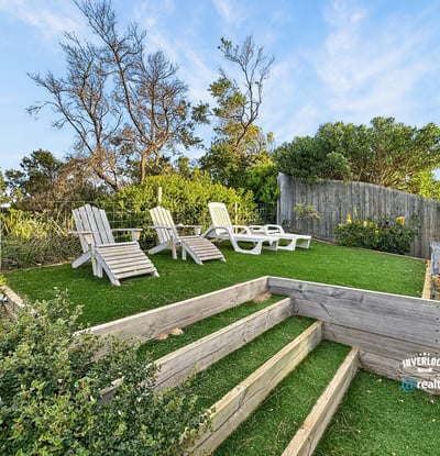 Discover a peaceful outdoor retreat featuring landscaped steps and ample seating for relaxation and enjoyment.
