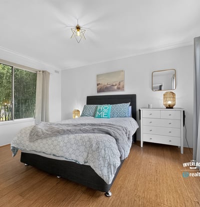 Spacious bedroom featuring abundant natural light, modern decor, and a cozy atmosphere for relaxation.