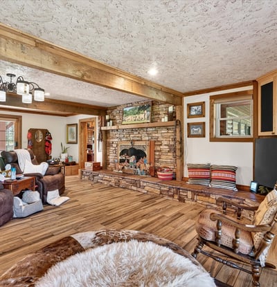 Discover a spacious living area featuring a unique stone fireplace and abundant natural light.