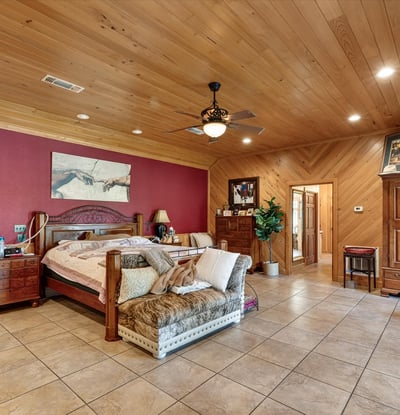 Spacious master bedroom featuring warm wood accents and ample natural light, perfect for relaxation and retreat.
