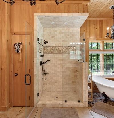 This luxurious bathroom features a spacious walk-in shower and a freestanding tub, surrounded by natural light.