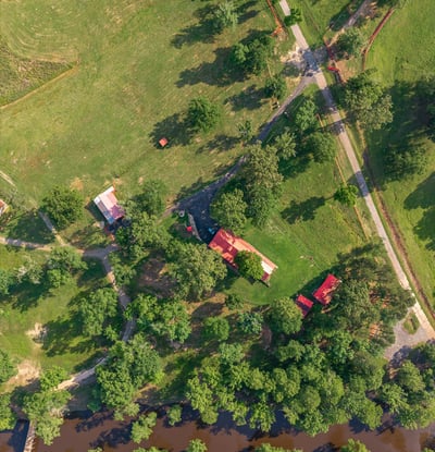 Discover a picturesque property featuring lush greenery, a winding river, and ample space for outdoor activities.