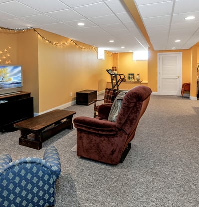 Amazing Finished Basement features a large recreation room with TV and exercise areas. Storage room at end. Sewing/craft area to the right.