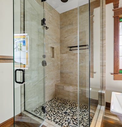 Elegant walk-in shower with detailed tilework, frameless glass, and built-in seating. A spa-like bathroom feature that reflects craftsmanship and modern comfort.