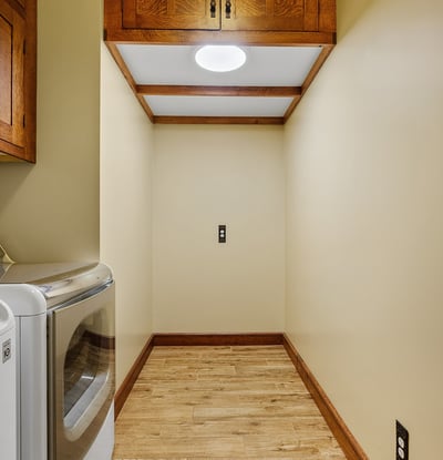 Functional laundry room offering overhead cabinetry, storage space, and durable finishes. Designed to support organization and efficiency.