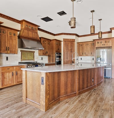 Gourmet kitchen featuring an oversized island, custom wood cabinetry, stone countertops, and professional-grade appliances. A standout space for cooking and entertaining.