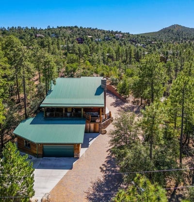 Sweeping aerial photo capturing the home s peaceful forest setting, mature pine trees, and elevated terrain perfect for buyers seeking privacy and scenic surroundings.