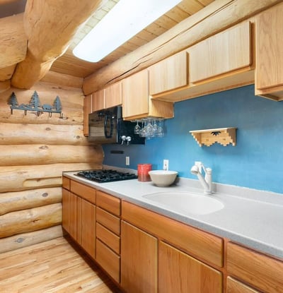 Functional kitchen design with ample storage, durable surfaces, and classic log home finishes tailored for everyday use.