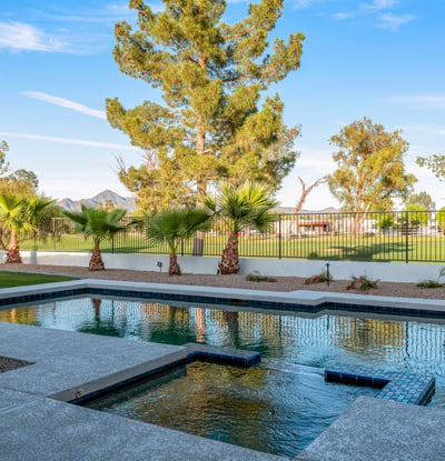 A sparkling pool with lush golf course views creates the perfect backyard oasis for this Scottsdale home, blending relaxation with elegance.