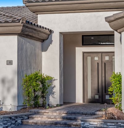 Modern double doors with glass accents make a bold statement at the entrance of this Scottsdale residence.