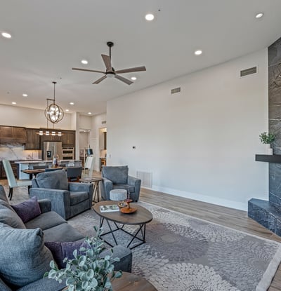 The family room connects to the kitchen with high ceilings, modern lighting, and a fireplace centerpiece for Scottsdale living.