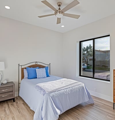 Bright guest bedroom with natural light, ceiling fan, and durable flooring makes a perfect Scottsdale guest space.