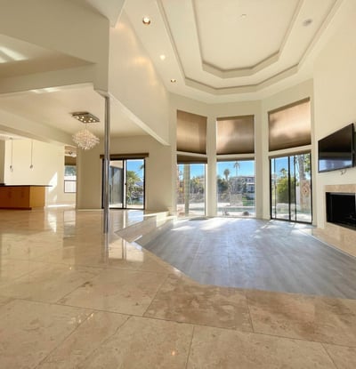 Grand open living area with marble floors, soaring ceilings, and wide windows that fill the space with Scottsdale sunshine.