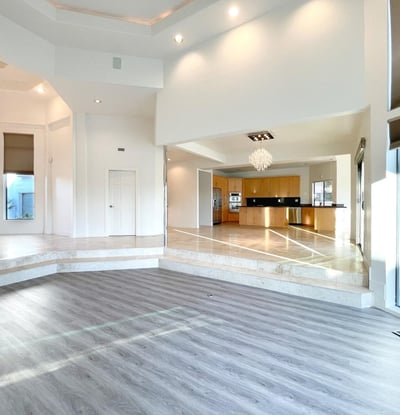 Expansive main living space framed by large windows, marble flooring, and designer chandeliers blending comfort and architectural grace.
