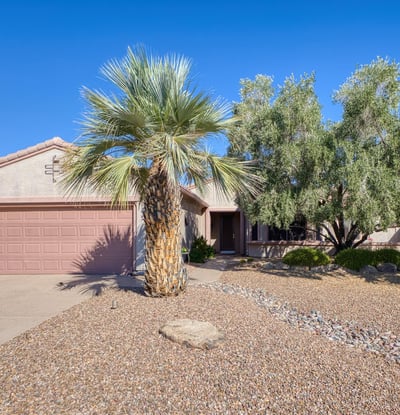 Featuring mature desert landscaping and a tiled roof, this energy-efficient home welcomes you with timeless Southwest design and exceptional curb appeal in Surprise.