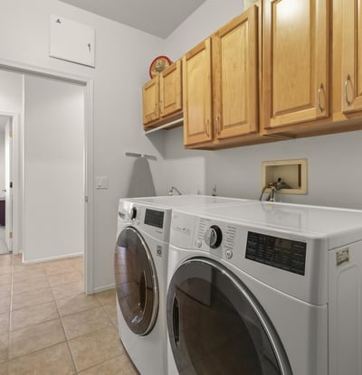 Efficient laundry room featuring full-size LG washer and dryer, cabinetry for storage, and bright, easy-care finishes.