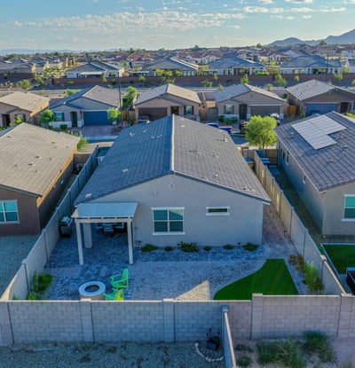 Drone shot highlighting the home s spacious outdoor layout, ideal for gatherings. Pavers, turf, and clean desert landscaping showcase modern comfort and style.