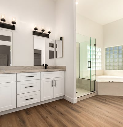 Elegant primary bathroom featuring dual sinks, modern cabinetry, and contemporary lighting. The Scottsdale bathroom connects to a spa-like shower and soaking tub for everyday comfort.