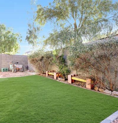 Artificial turf side yard with planter beds provides a low-maintenance, pet-friendly outdoor space designed for everyday enjoyment.