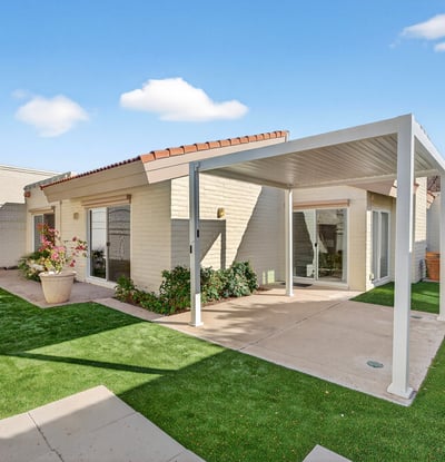Private backyard with covered patio and turf landscaping, designed for easy care and outdoor enjoyment in Phoenix.