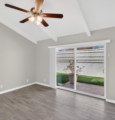 Bedroom featuring sliding glass doors to the courtyard, vaulted ceiling, and bright natural light enhancing the living experience.