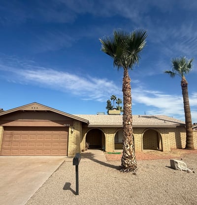 Beautiful exterior view of this Glendale property featuring mature palm trees, desert landscaping, and durable block construction. The home offers strong curb appeal with a welcoming front driveway and garage.