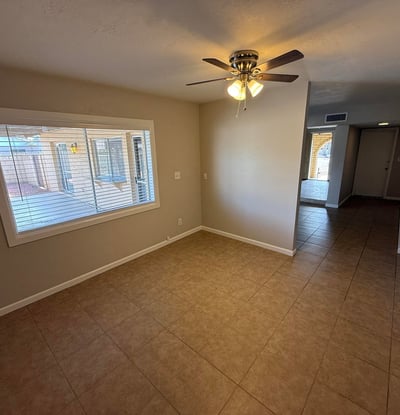 Bedroom with sliding doors opening directly to the backyard patio and pool area. Natural light and tile flooring enhance the bright feel of the room.