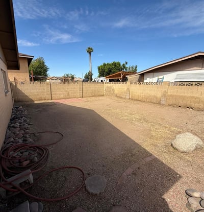 Expansive backyard area with low-maintenance desert landscaping and block wall fencing. The generous outdoor space offers flexibility for entertaining, recreation, or customizing future landscaping.