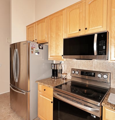Cooking area with stainless steel range, built-in microwave, and tiled backsplash. This Phoenix home includes updated features and efficient layout.