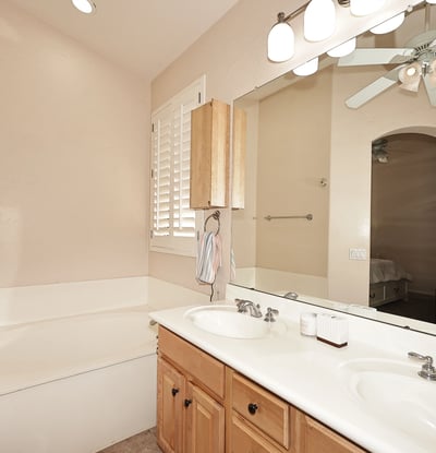 Primary bathroom with dual sinks, large mirror, and bright lighting. This Phoenix home offers convenience and comfort in a well-designed layout.