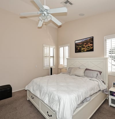 Comfortable primary suite with large windows, soft carpet, and open layout. This Phoenix home provides a relaxing retreat with functional space and natural light.