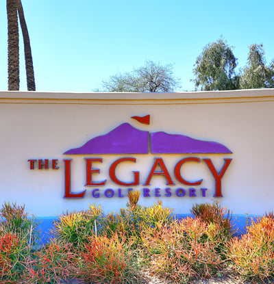 The Legacy Golf Resort sign set among desert plants and clean hardscape. This Phoenix location offers access to golf, recreation, and scenic surroundings.